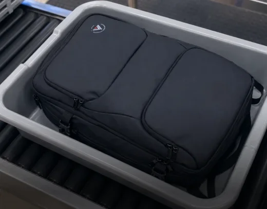 Voyge vacuum backpack in an airport security screening tray